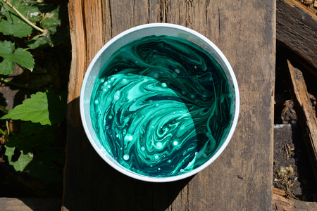 Mixed green acrylic colors in plastic box.   Fluid art.