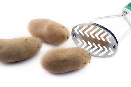 Potatoes and masher against white backgroundの写真素材