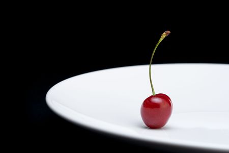 Cherry on a plate against white background
