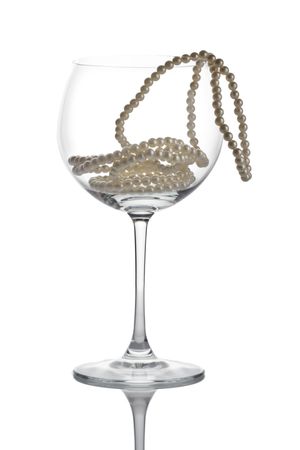 Wine glass and a pearls against white backgroundの写真素材