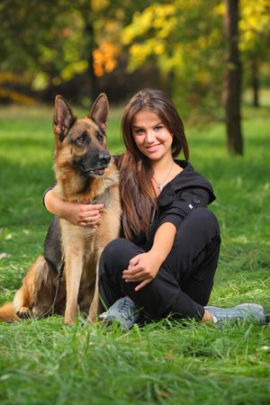 Smiling teenager hugging a German Sheppard dogの写真素材
