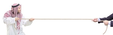 An arab person and a businessman pulling a rope isolated on white backgroundの写真素材