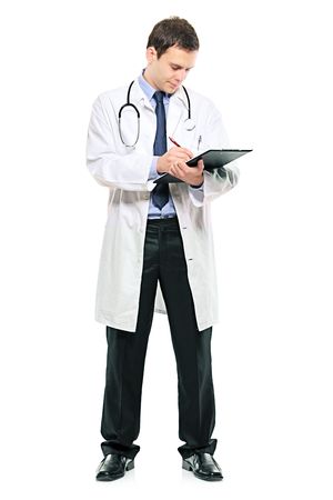 A young male doctor writing down notes against white backgroundの写真素材