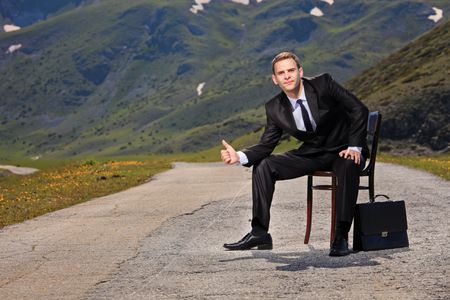 Businessman hitchhiking on a highway の写真素材