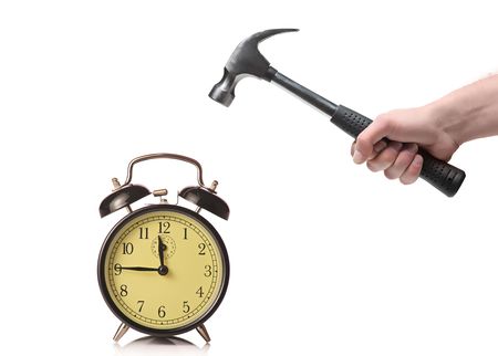 A man about to break an old clock isolated on a white backgroundの写真素材