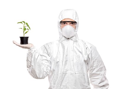 A man in uniform holding a plant isolated on white backgroundの写真素材