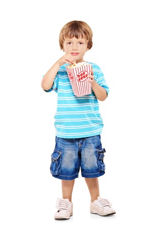 Full length portrait of adorable young boy eating popcorn isolated against white backgroundの写真素材