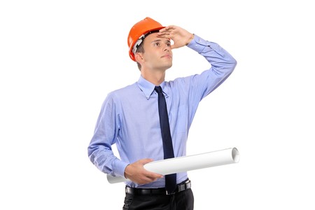 Construction worker holding blueprints and looking isolated against white backgroundの写真素材