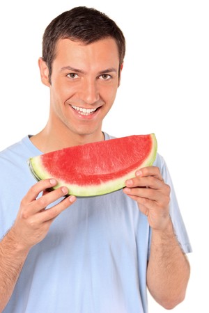 Smiling young man showing a slice of watermelon isolated on white backgroundの写真素材
