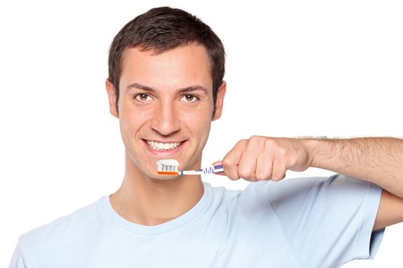A young man brushing his teeth isolated on white backgroundの写真素材
