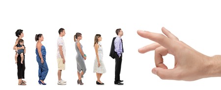 Full length portrait of men and women standing together in a line with a hand about to push them isolated against white backgroundの写真素材