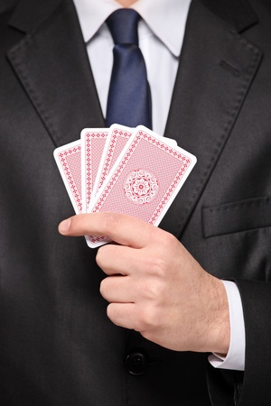 A close up of a man holding a four cards playing pokerの写真素材