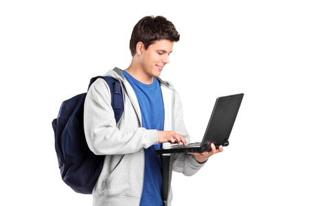 A portrait of a male student with a school bag working on a laptop isolated on white backgroundの写真素材