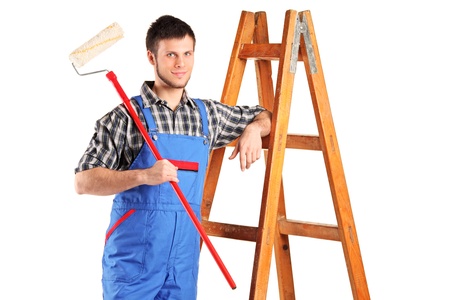 Smiling painter with a paint roller posing isolated on white backgroundの写真素材