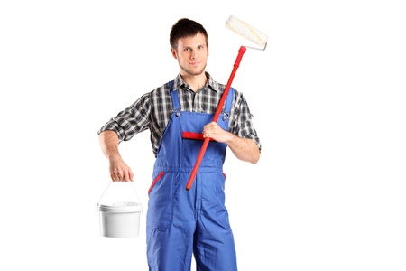 Smiling worker man holding a paint roller and bucket isolated on white backgroundの写真素材