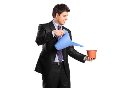 Portrait of a businessman holding an empty flower pot and watering can isolated on white backgroundの写真素材