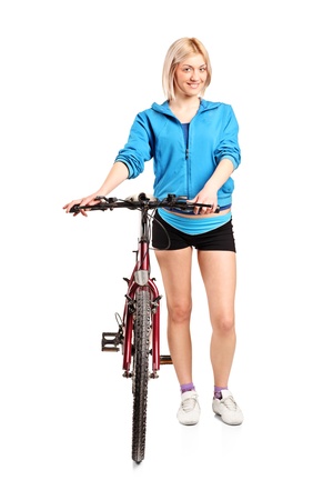 A blond female posing next to a bicycle isolated on white backgroundの写真素材