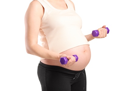 A pregnant woman working out with weights isolated on whiteの写真素材