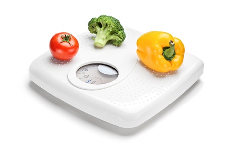 Vegetables on a weight scale isolated on white backgroundの写真素材