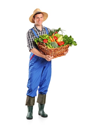 Full length portrait of a farmer holding a basket of vegetables isolated on white backgroundの写真素材