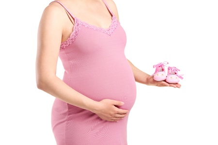 A pregnant woman holding baby shoes isolated on white backgroundの写真素材