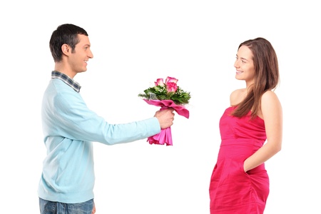 Boyfriend giving bunch of flowers to his girlfriend isolated on white backgroundの写真素材