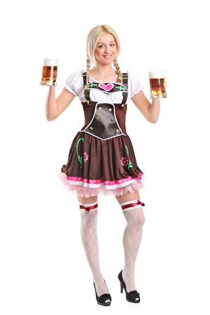 Full length portrait of a blond woman with traditional costume holding beer glasses isolated on white backgroundの写真素材