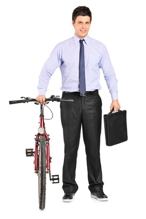 Full length portrait of a young businessman posing next to a bicycle isolated on white backgroundの写真素材