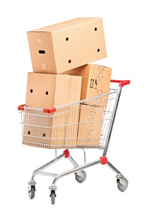 Shopping cart and stack of cardboard boxes isolated on white backgroundの写真素材
