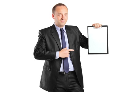 Young smiling businessperson pointing to a blank clipboard isolated on white backgroundの写真素材