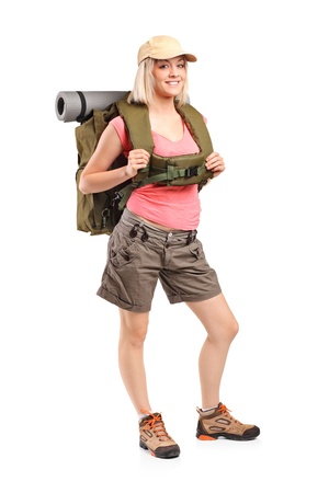 Full length portrait of a woman in sportswear with backpack posing isolated on white backgroundの写真素材