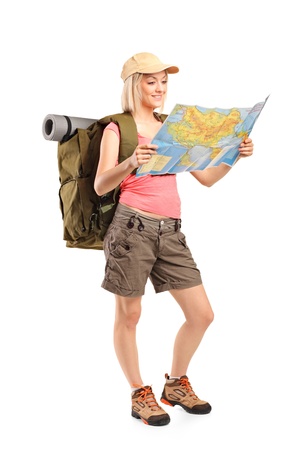 Full length portrait of female hiker looking at map isolated on white backgroundの写真素材