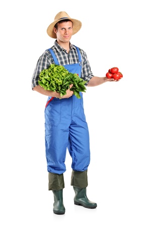 Full length portrait of a male farmer holding vegetables isolated on white backgroundの写真素材