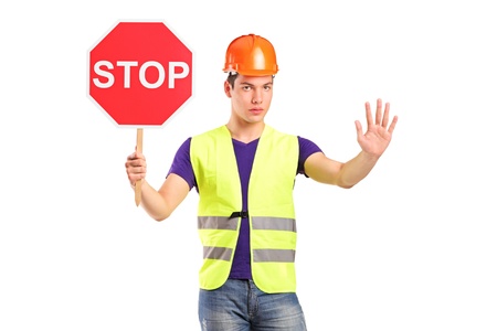 A construction worker holding a traffic sign stop isolated on white backgroundの写真素材