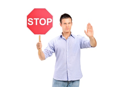 A man gesturing and holding a traffic sign stop isolated on white backgroundの写真素材