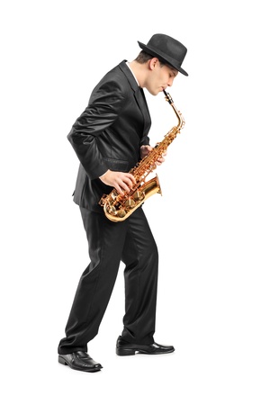 Full length portrait of a young man playing on saxophone isolated on backgroundの写真素材