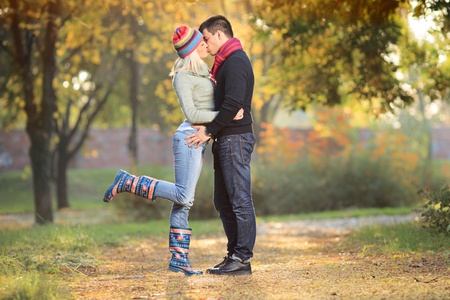Loving couple kissing in the park in autumnの写真素材