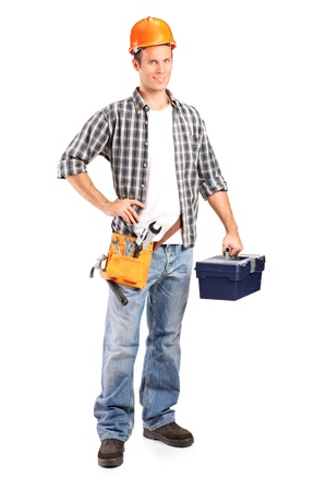 Full length portrait of a confident and smiling manual worker holding a wrench and a toolbox isolated on white backgroundの写真素材