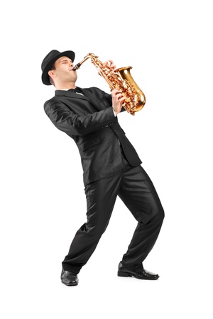 Full length portrait of a man in a suit playing on saxophone isolated on backgroundの写真素材