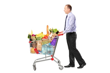 Person pushing a shopping cart full with groceries isolated on white backgroundの写真素材