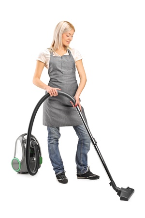 Full length portrait of a female cleaning with vacuum cleaner isolated on white backgroundの写真素材