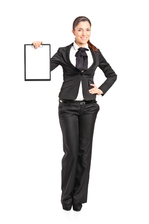 Full length portrait of a young businesswoman holding an empty clipboard isolated on white backgroundの写真素材