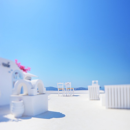 Minimalistic shot of two chairs against blue sky shot on Santorini island, Greece with tilt and shift lens and shallow DOF with the focus on the chairsの写真素材