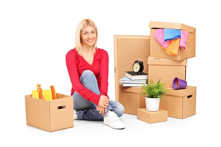 Smiling woman resting from moving into a new home with many boxes around herの写真素材