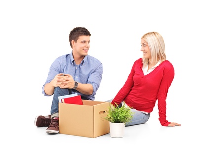 Young man with his woman sitting and resting after moving into a new home isolated on whiteの写真素材