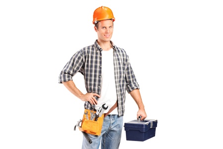 A confident and smiling manual worker holding a wrench and a toolbox isolated on white backgroundの写真素材
