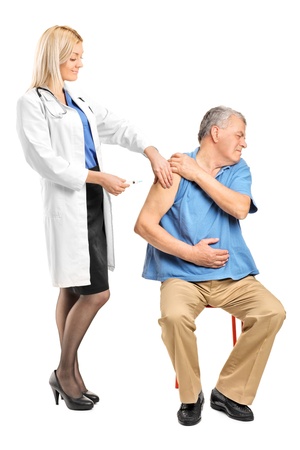 Female doctor applying a syringe to an elderly man isolated on white backgroundの写真素材