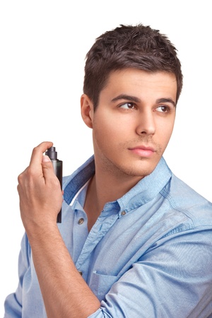 A handsome young man using perfume isolated on white backgroundの写真素材