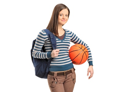 A young school girl holding a basketball isolated on white backgroundの写真素材