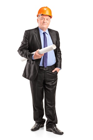 Full length portrait of a mature construction worker with helmet holding blueprints isolated on white backgroundの写真素材